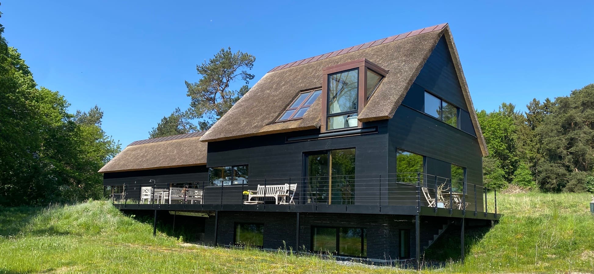 Arkitekttegnet hus med stråtag og kobberkvist